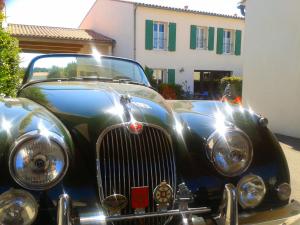 an old car parked in front of a building at Hôtel La Galiote en Ré in La Flotte