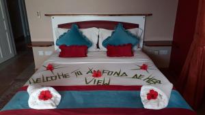 a bed with red and blue pillows and a sign on it at Au Fond De Mer View in Anse Royale