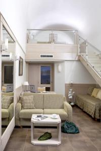 a living room with two couches and a staircase at Thalassa Beach Resort & Spa (Adults Only) in Agia Marina Nea Kydonias