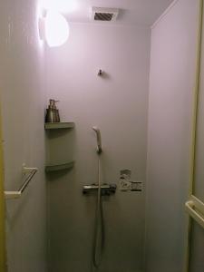 uma cabina de duche na casa de banho com um chuveiro em yado & kissa UGO HUB em Yuzawa