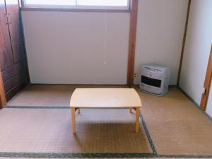 a small table in a room with a microwave at yado & kissa UGO HUB in Yuzawa