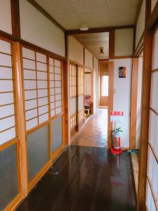 a hallway of a room with wooden floors and windows at yado & kissa UGO HUB in Yuzawa