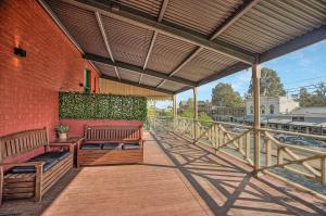 a balcony with two benches on a brick building at Little Hopwood Apartment No1 in Echuca