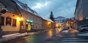 a city street with buildings on a snowy street at Apartman Okamih Banská Štiavnica in Banská Štiavnica