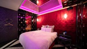 a bedroom with a large bed with a red wall at I-more Motel in Yonghe