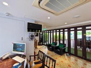 a living room with a desk with a computer and a television at Lertnimit Boutique Hotel in Hua Hin