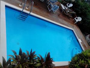 una gran piscina con 2 sillas en una terraza en The Ocean Inn Antigua, en English Harbour Town