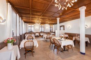 a restaurant with tables and chairs and a chandelier at Hotel am Markt in Baden-Baden