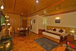 Habitación de hotel con cama y comedor en Hotel Broadways Inn, en Manali