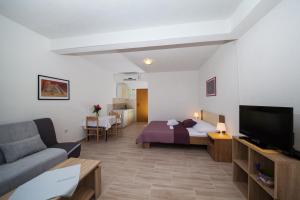 sala de estar con cama y sofá en Apartments Kovačić, en Makarska