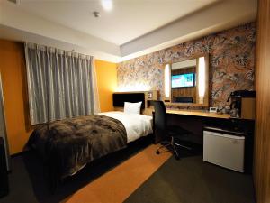 a hotel room with a bed and a desk and a mirror at Green Rich Hotel Miyazaki Tachibandori 2 (Artificial hot spring Futamata Yunohana) in Miyazaki