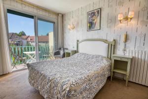 a bedroom with a bed and a balcony at Le Quercy in Souillac