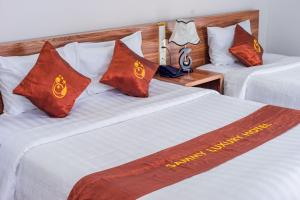 two beds with red pillows in a hotel room at Malina Luxury Villa in Da Thien