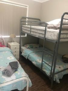 a bedroom with two bunk beds and a lamp at Surf Mist in Nowra