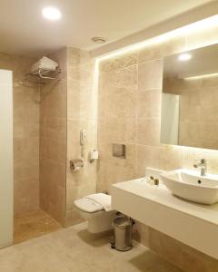 a bathroom with a sink, toilet and shower at Royal Asarlik Beach Hotel - Ultra All Inclusive in Gümbet
