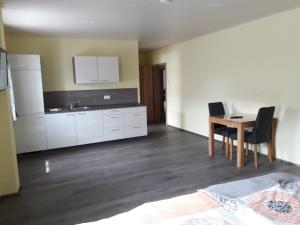 a kitchen and dining room with a table and chairs at Schoppenstube May in Weigenheim