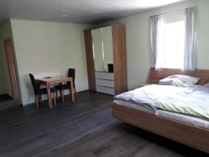 a bedroom with a bed and a table and a mirror at Schoppenstube May in Weigenheim