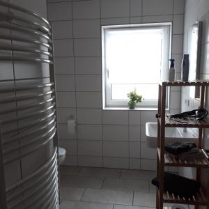 a bathroom with a shower and a sink and a window at Schoppenstube May in Weigenheim