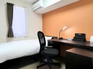 Higashimatsushima的住宿－東松島矢本最佳價值酒店，酒店客房配有一张床和一张带电脑的书桌
