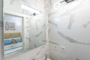 a white bathroom with a mirror and a sink at GreenEscapes II in Porto Covo +20 photos