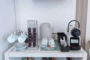 a white shelf with dishes and a blender on it at GreenEscapes II in Porto Covo