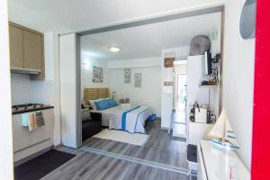 a small bedroom with a bed and a kitchen at GreenEscapes II in Porto Covo