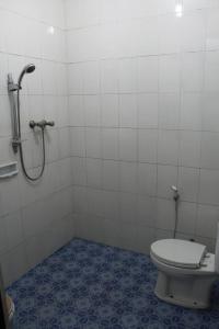a bathroom with a toilet and a shower at Parama Hotel in Wonosobo