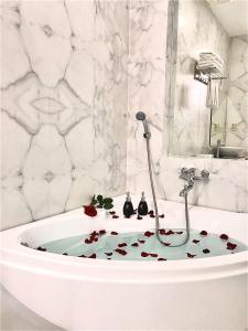 baño con bañera y decoración floral en el suelo en Anh Nguyet Da Nang Hotel en Da Nang