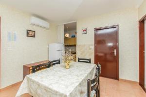ein Esszimmer mit einem Tisch und einer Küche in der Unterkunft Apartment Barbara in Batalaži