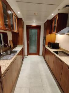 a large kitchen with wooden cabinets and a door at Holiday Homes in Dubai