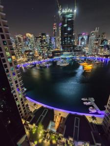 a view of a city at night with boats in the water at Holiday Homes in Dubai