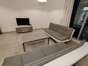 a living room with a couch and a tv at Holiday Homes in Dubai