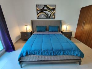 a bedroom with a blue bed with two night stands at Holiday Homes in Dubai