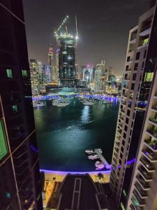 a view of a city at night with boats in the water at Holiday Homes in Dubai