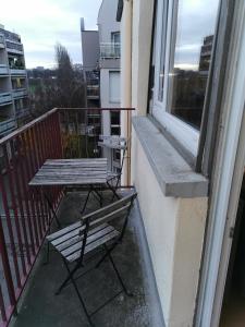 une table et des chaises sur le balcon d'un bâtiment dans l'établissement La Charmille, charmant 2P proche tram, à Strasbourg