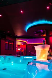 um quarto com uma banheira com luzes roxas e azuis em L'Insolite Spa Privatif ''Suite Luxueuse-Jacuzzi" em Toulouse