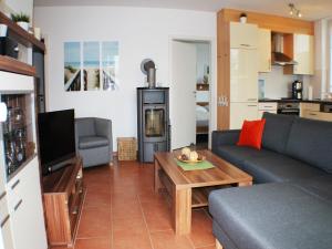 a living room with a couch and a tv and a table at Windrose 7 in Großenbrode