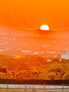 un tableau représentant un coucher de soleil avec le soleil dans le ciel dans l'établissement Estrada de, Urbanizacao,edificio laranjal,apartment 18,vale carro, 8200-596, à Albufeira