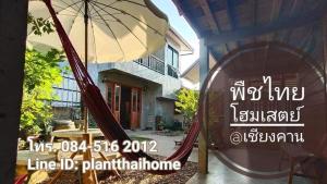 ein Schild vor einem Haus mit einer Hängematte und einem Sonnenschirm in der Unterkunft พืชไทยเชียงคาน(Plantthai) in Chiang Khan