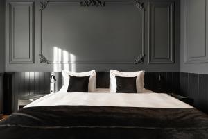 una camera da letto con un grande letto con due cuscini di Potocki Boutique Hotel a Chmel'nyc'kyj
