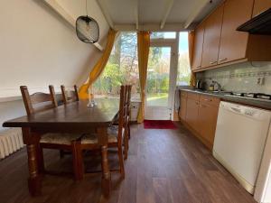 een keuken met een tafel en stoelen en een raam bij Rust in Voorthuizen