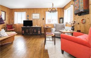 una sala de estar con paneles de madera y muebles de color rojo. en Awesome Home In Sankt Veit-defereggenta With Kitchen, en Gassen