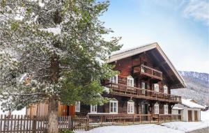 una gran casa de madera con una valla en la nieve en Awesome Home In Sankt Veit-defereggenta With Kitchen, en Gassen