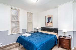a bedroom with a blue bed in a room with windows at Beautiful Apartment on the west side in Buffalo in Buffalo