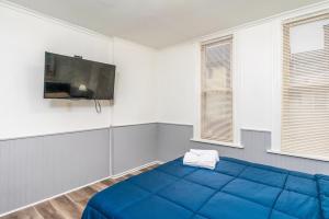 a bedroom with a blue bed and a flat screen tv at Beautiful Apartment on the west side in Buffalo in Buffalo