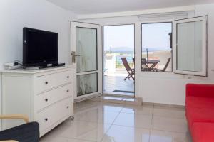 a living room with a flat screen tv on a dresser at BougainvillaStudio in Cesme