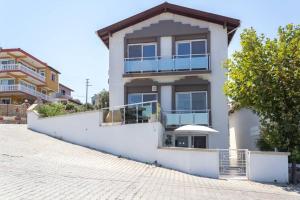 a white house with a balcony on a street at BougainvillaStudio in Cesme
