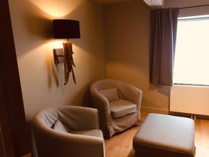 a living room with two chairs and a table at Hotel le Fenil in Celles