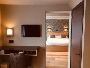 Habitación de hotel con cama y TV de pantalla plana. en Hotel le Fenil, en Celles