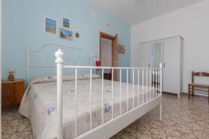 1 dormitorio con 1 cama blanca y paredes azules en Casa Bouganville by BarbarHouse, en San Pietro in Bevagna